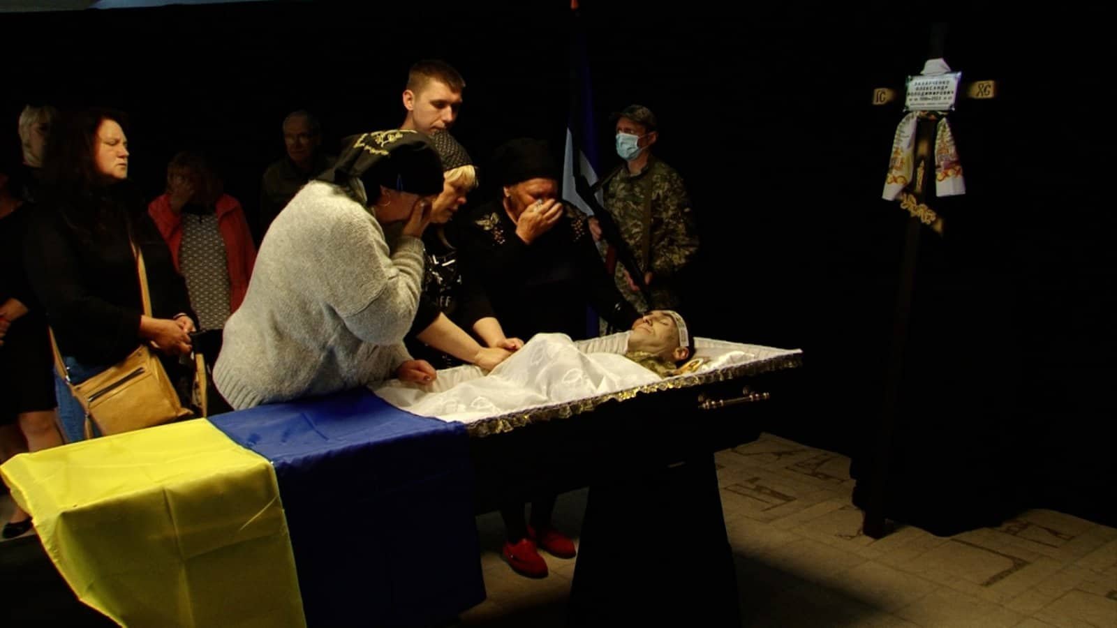 Рідні схилилися над домовиною Олександра Захарченка, яке огорнуте жовто-блакитним стягом України