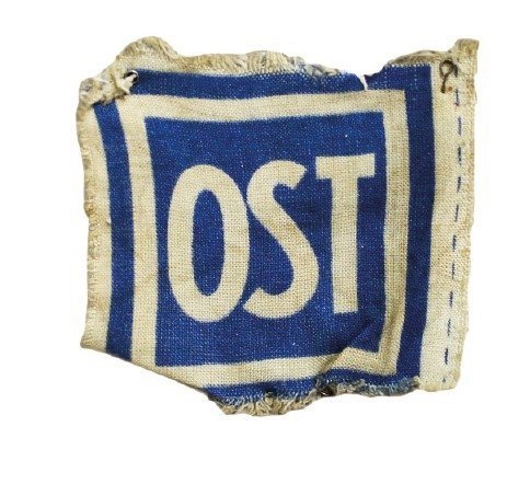 Остарбайтери були зобов'язані носити нашивку темно-блакитного й білого кольорів з написом «OST» (нім. «Схід»), яка повідомляла німцям, що ці люди — робітники зі Сходу, та понижувала їх у правах