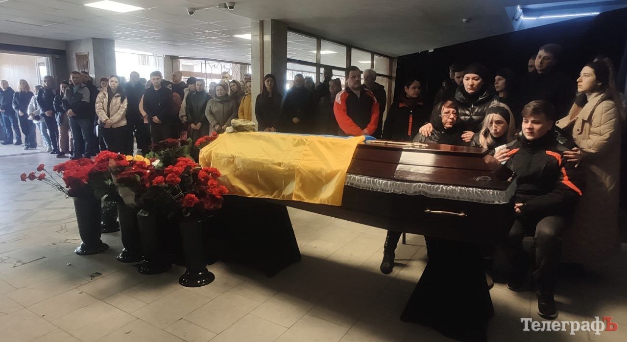 Над домовиною огорнутою у синьо-жовтий стяг схилилися згорьовані дружина, 15-річний син, матір та друзі