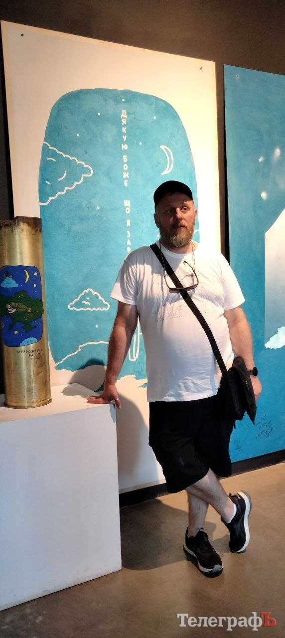 Нікіта Тітов на фоні свого плаката на Промприлад. Реновація в Івано-Франківську